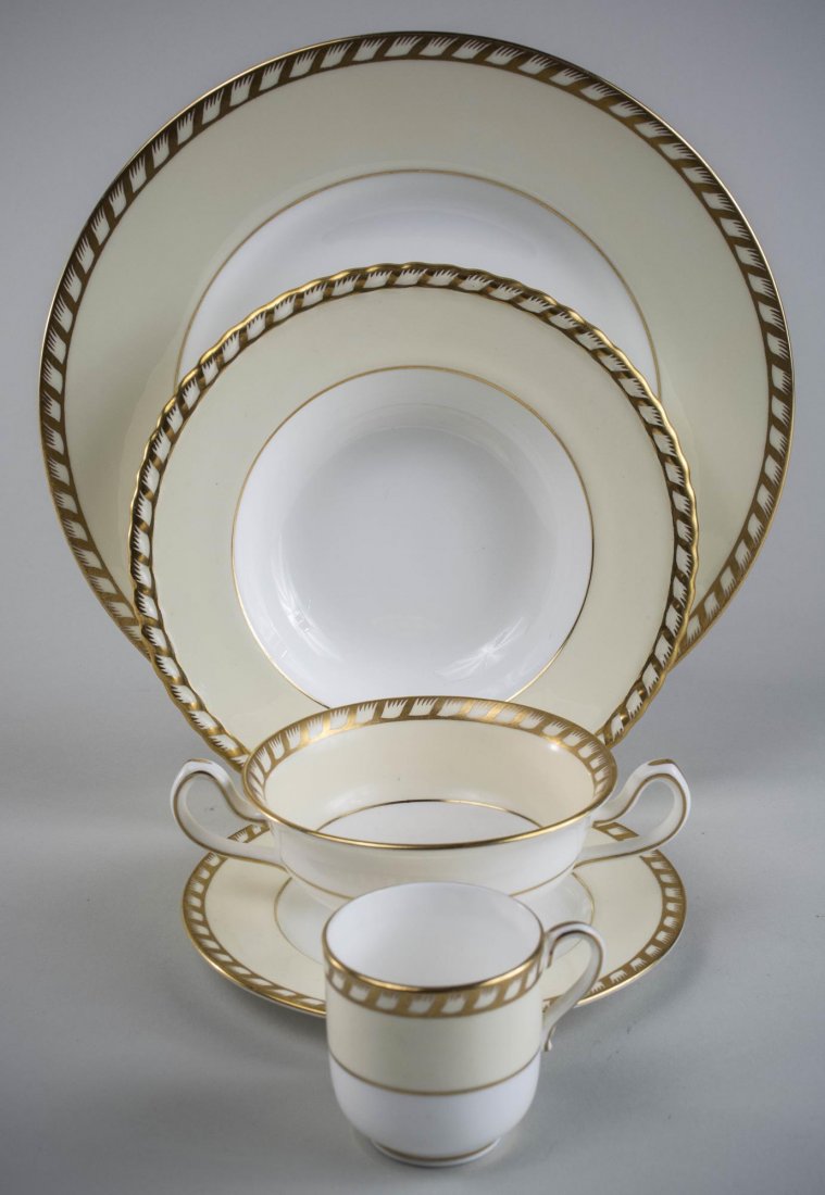 Mintons Porcelain Dinner Service: Approximately fifty eight pieces, Commodore pattern, S112, cream with gold trim, comprising nine dinner plates, vegetable bowl, eight cream soup bowls and underplates, eight demitasse cups and seven d