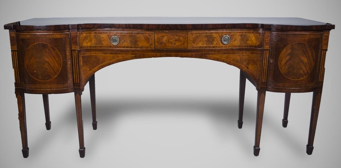 Federal Style Inlaid Mahogany Sideboard: Shaped rectangular top over drawers and two cabinets, square tapered legs. Height 38 inches, width 7 feet, depth 25 inches. Notice to bidders: Condition reports and additional photographs are provided