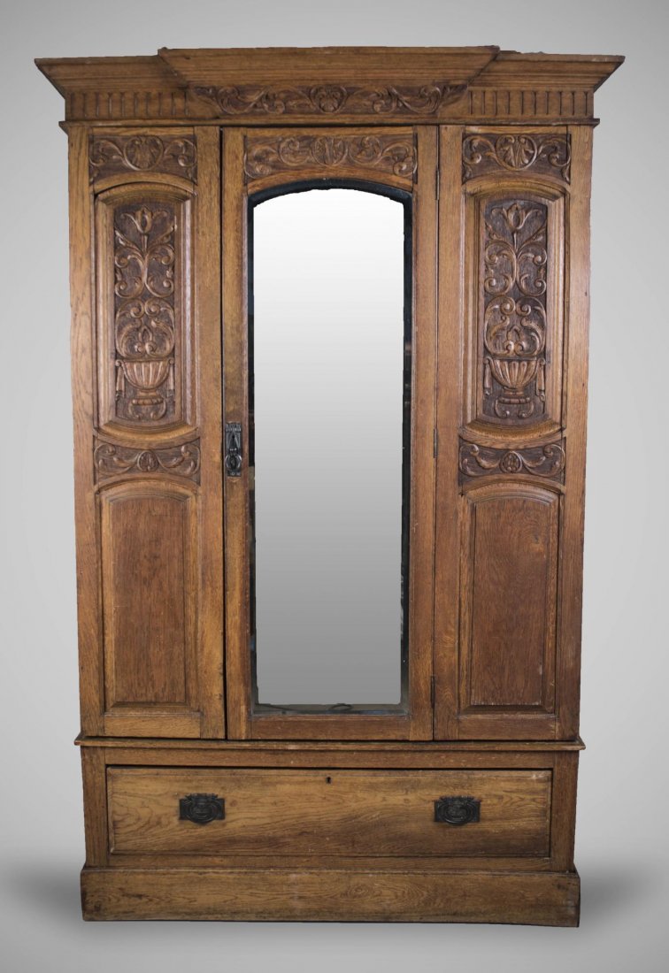 Armoire: Breakfronted cornice over a central mirrored door, flanked by carved panels and above a long drawer. Height 6 feet 8 inches, width 47 inches, depth 18 inches. Notice to bidders: Condition reports and 