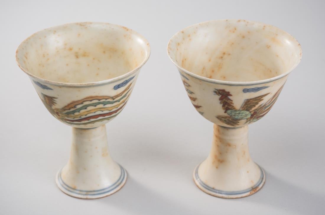 Pair of Chinese Cups: Ming dynasty mark, decorated with phoenix birds, signed. Height 3 1/2 inches. Notice to bidders: Condition reports and additional photographs are provided by request as a courtesy to our clients, as s