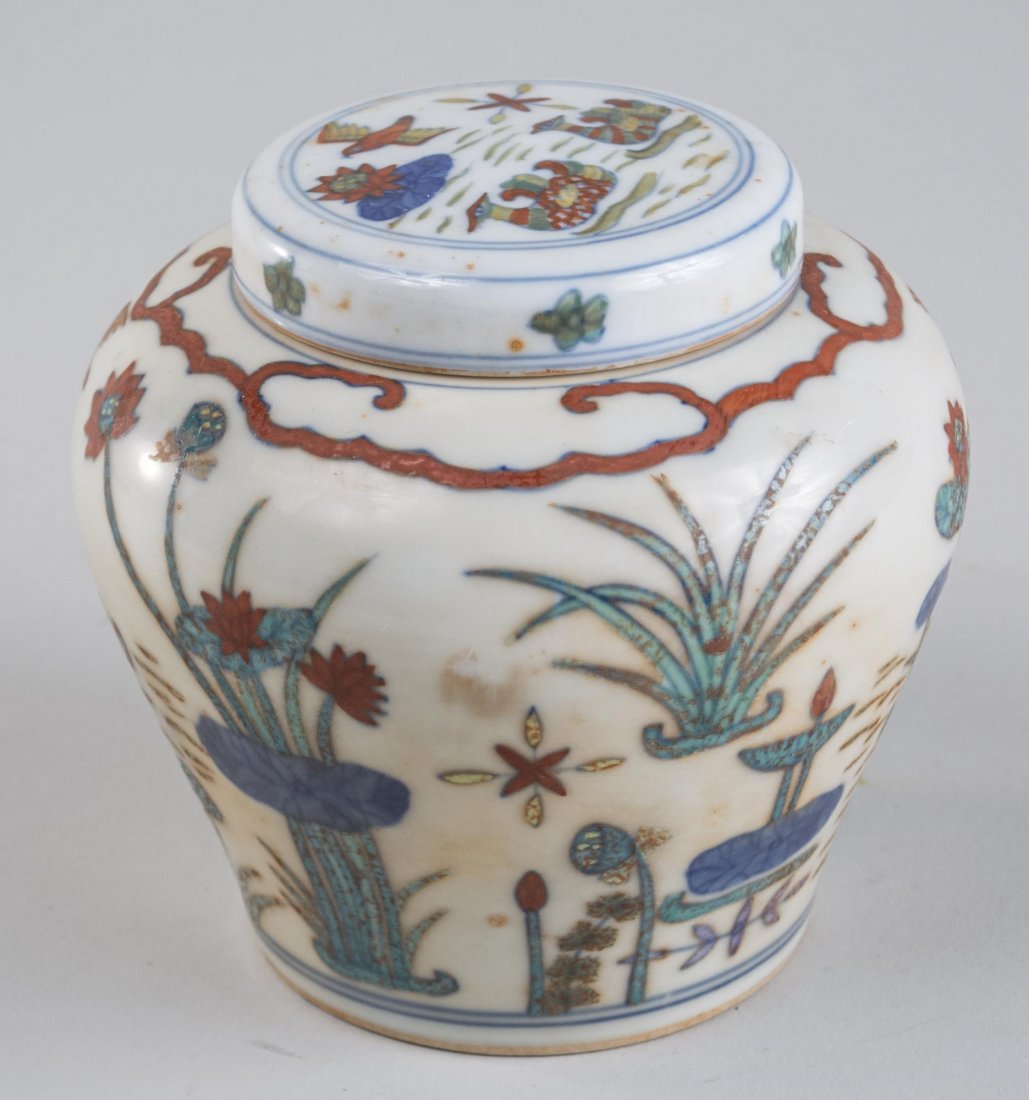 Chinese Covered Jar: Ming dynasty mark, inverted baluster body with floral decoration. Height 4 1/2 inches. Notice to bidders: Condition reports and additional photographs are provided by request as a courtesy to our clie