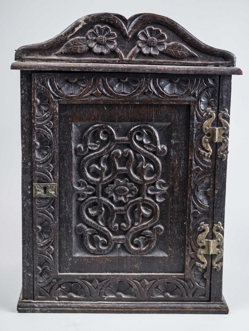 Carved Wood Hanging Cabinet: Late 18th - early 19th century, Renaissance style, with carved scrolls and flowers, broken arch pediment over a single door. Height 16 inches, width 14 3/4 inches, depth 11 inches. Notice to bidders: 