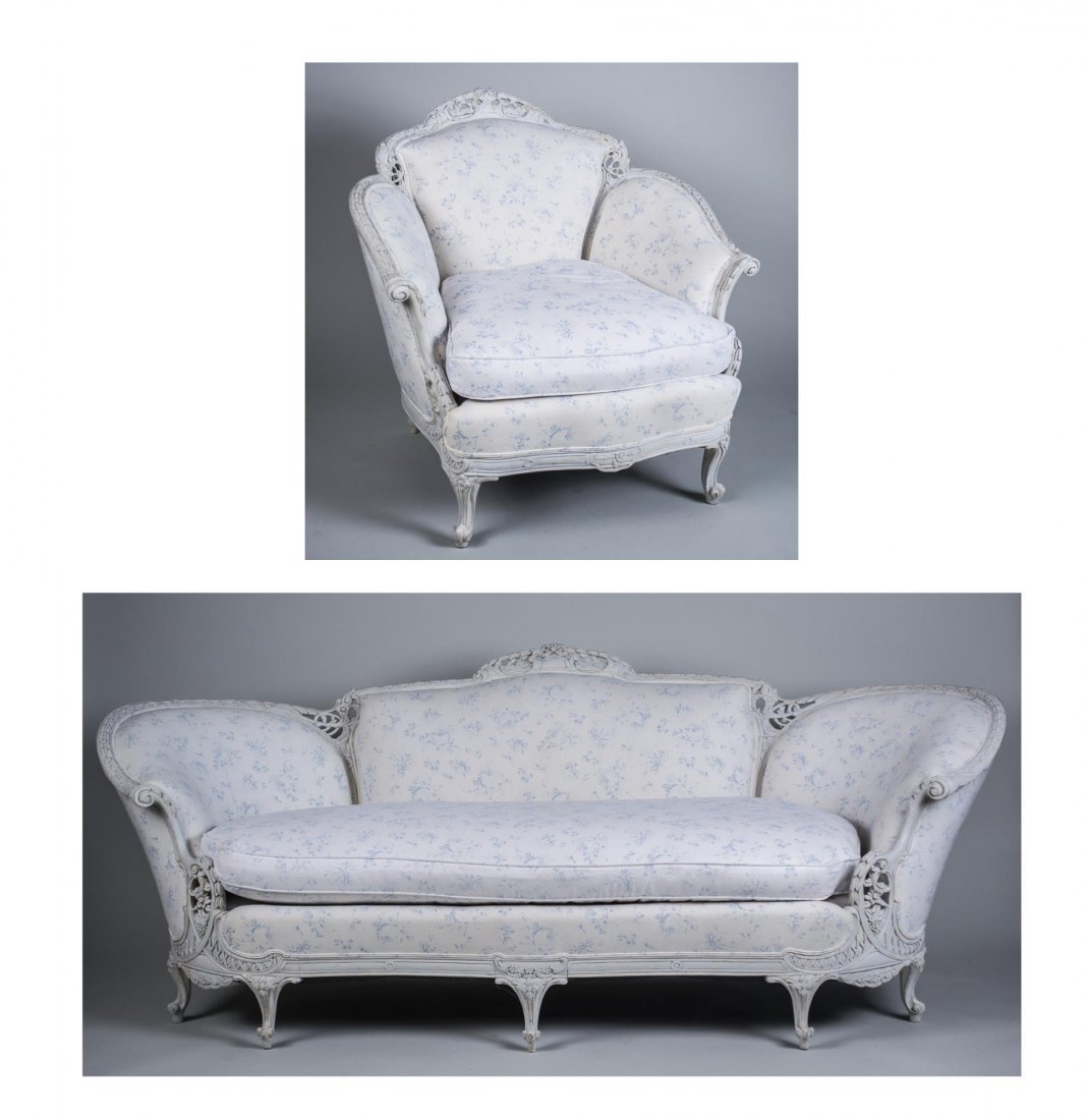 White Painted Parlor Suite: Comprising a settee and a chair with floral carved decoration. Settee. Height 37 inches, width 7 feet 4 inches, depth 34 inches. Notice to bidders: Condition reports and additional photographs are pro
