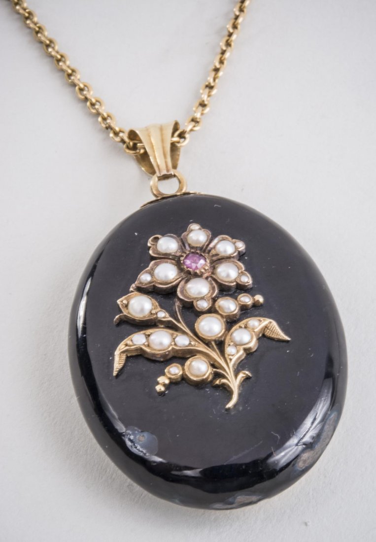Black Onyx and Half Pearl Picture Locket *: Oval locket set with half pearl on a 18k yellow gold chain. Length 19 inches. Chain 9.4 grams. Notice to bidders: Condition reports and additional photographs are provided by request as a courtesy to 