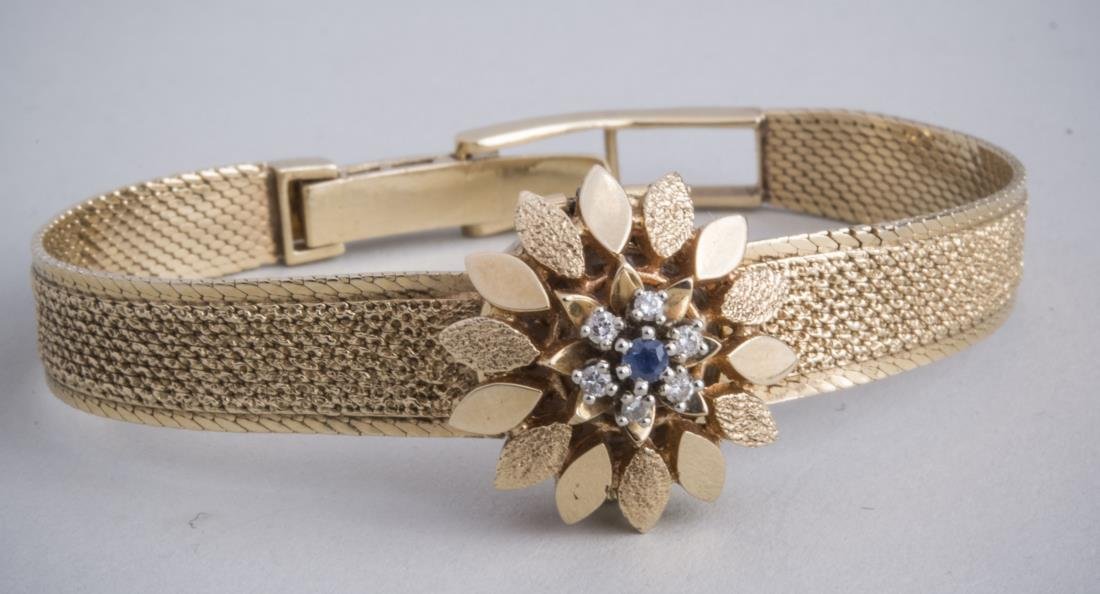 Lady's Movado Gold Wristwatch *: 14k yellow gold bracelet watch, dial with flower florm cover accented with round diamonds, in original box. Notice to bidders: Condition reports and additional photographs are provided by request as a