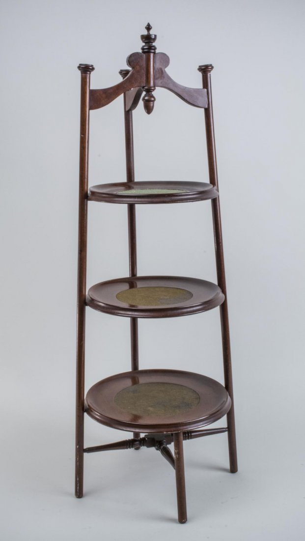 Victorian Style Mahogany Cake Stand: Three graduated folding shelves. Height 33 inches, diameter 12 inches. Notice to bidders: Condition reports and additional photographs are provided by request as a courtesy to our clients, as such any