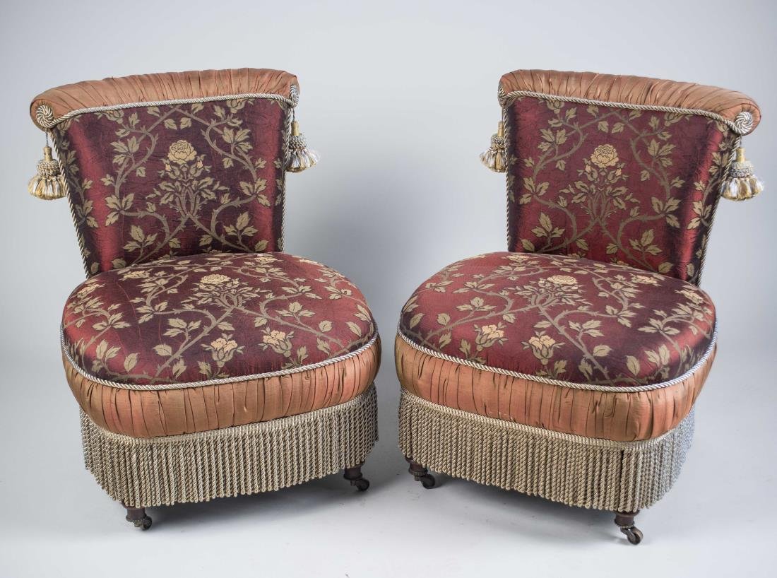 Pair of Slipper Chairs: Each with flower print upholstery on wine ground, fringe border. Height 29 inches, width 23 inches, depth 27 inches. Notice to bidders: Condition reports and additional photographs are provided by req