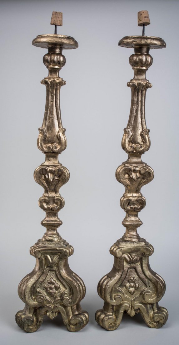 Pair of Gold Painted Altar Candlesticks: Carved and gold painted sticks with scroll and leaf decoration, on a tripod base. Height 32 inches. Notice to bidders: Condition reports and additional photographs are provided by request as a courtes