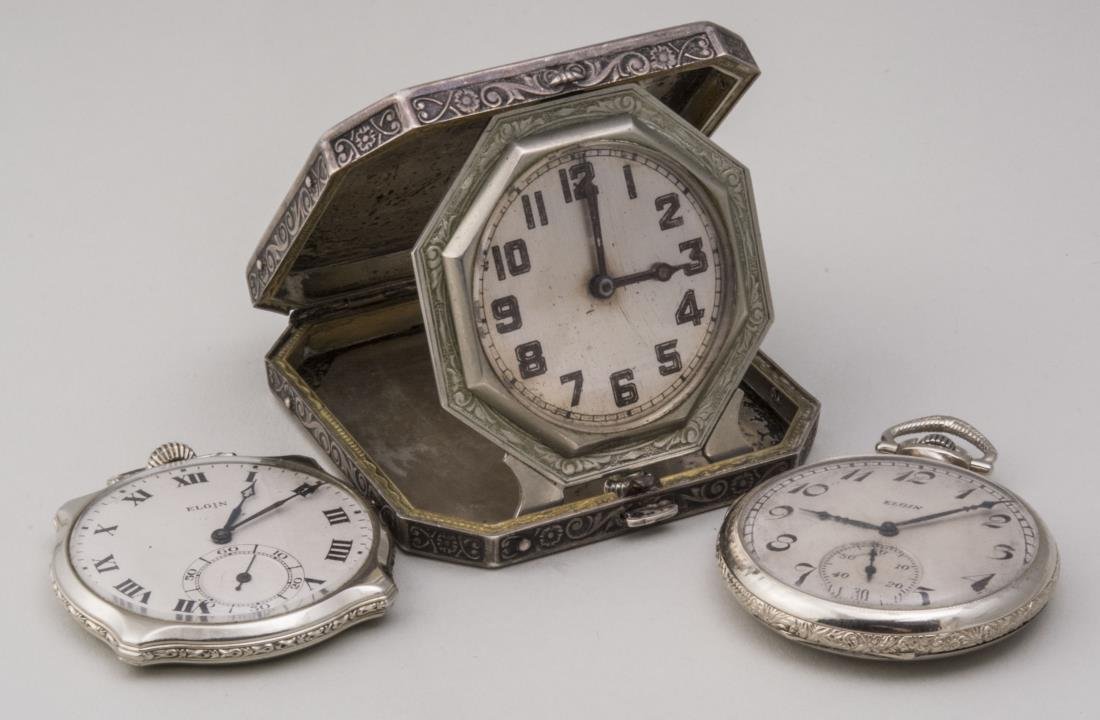 Three Elgin Watches: Sterling silver case travel clock, 2 1/2 x 2 1/2 inches; and two pocket watches, one with Roman numerals, diameter 1 3/4 inches; the other, Arabic numerals, diameter 1 3/4 inches. Notice to bidders: C