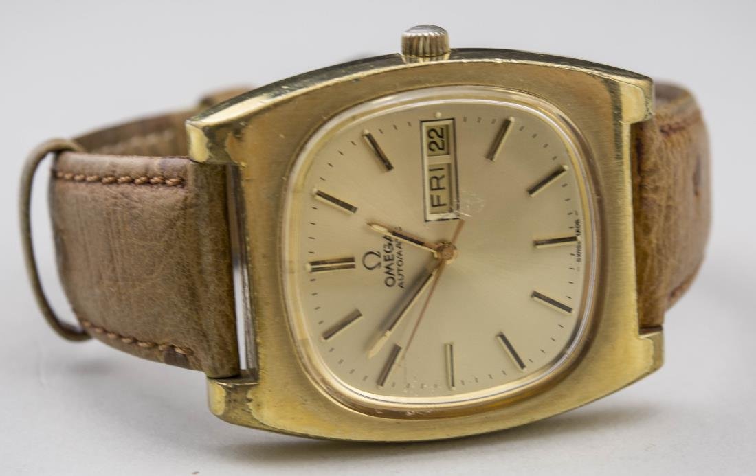 Omega Wristwatch: Omega Automatic gold tone watch, dial with baton hours and date aperture, brown ostrich grain band. Length 8 1/2 inches. Notice to bidders: Condition reports and additional photographs are provided by