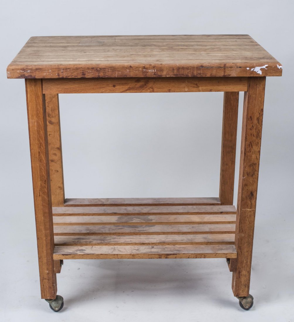 Butcher Block Side Table: Rectangular top on square legs ending in casters and joined by a lower shelf. Height 34 inches, width 30 inches, depth 18 inches. Notice to bidders: Condition reports and additional photographs are pr