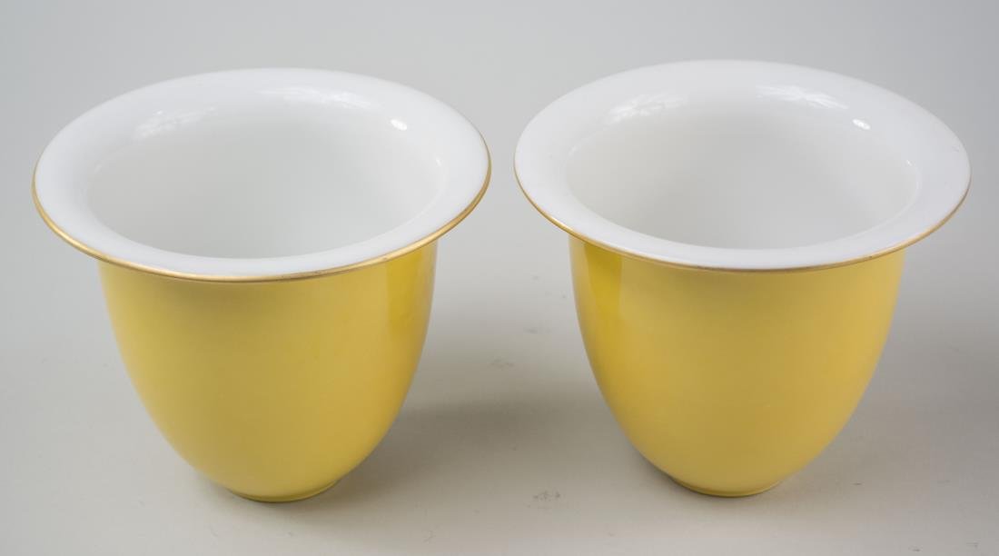 Pair of KPM Porcelain Cachepots: Yellow exterior. Height 5 inches, diameter 6 inches. Notice to bidders: Condition reports and additional photographs are provided by request as a courtesy to our clients, as such any condition report