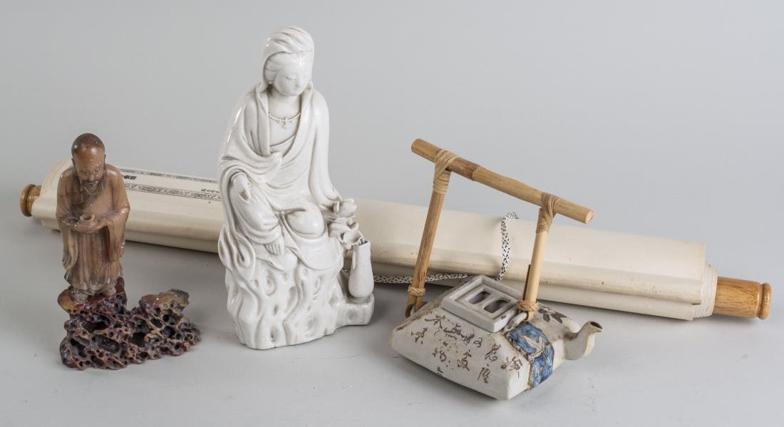 Group of Four Asian Decorations: Comprising a Blanc de Chine Quan Yin, a carved hardstone elder figure, a Malaysian porcelain teapot, and a scroll painting. Quan Yin height 9 1/2 inches. Notice to bidders: Condition reports and addit