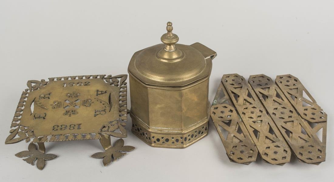 Two Brass Trivets and a Brass Box: Including one extendable trivet. Box height 8 inches Notice to bidders: Condition reports and additional photographs are provided by request as a courtesy to our clients, as such any condition report