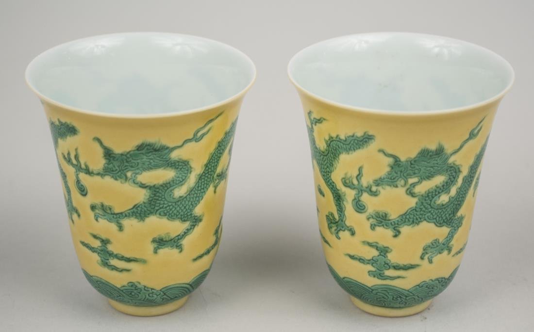 Pair of Chinese Porcelain Beakers: Ring foot, green dragons on yellow ground, signed on bottom. Height, 3 inches. Provenance: From the Collection of Erwin A. Raible Notice to bidders: Condition reports and additional photographs are pr