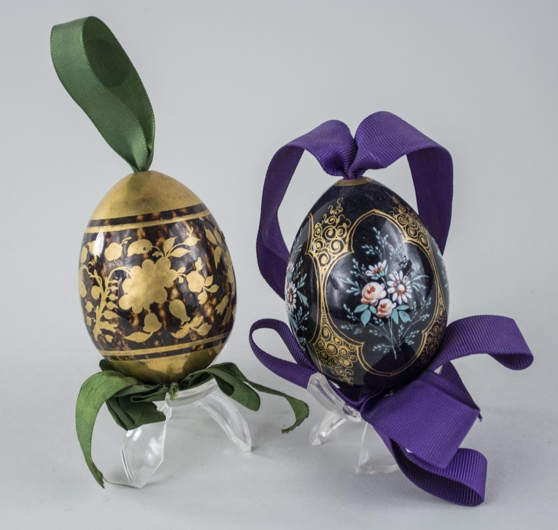 Two Russian Porcelain Easter Eggs: One with enamel decoration, flowers, on a black ground with gilt highlights, the other with gilt floral decoration on simulated tortoise background. Height, 3 inches. Provenance: From the Collection o