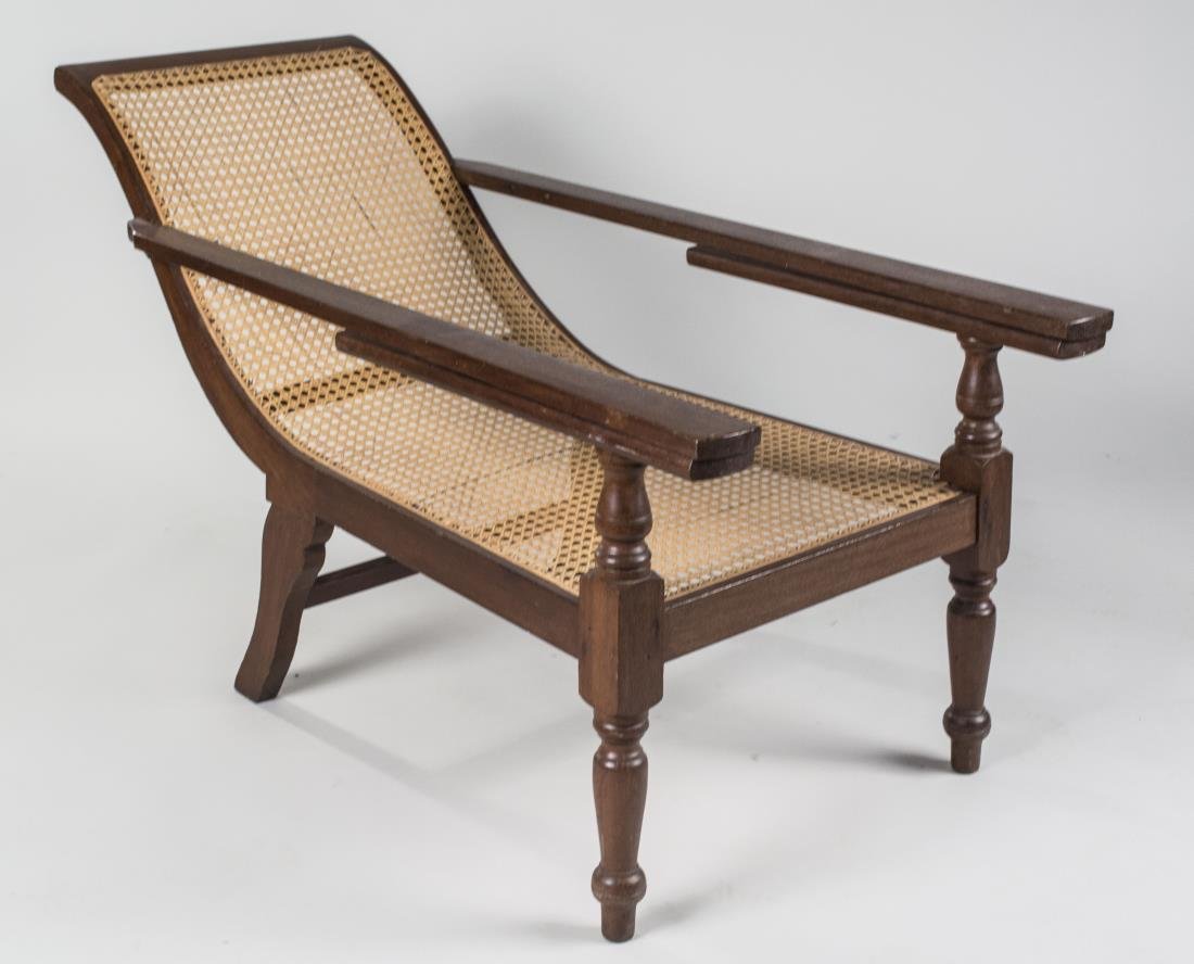 Caned Planter's Armchair: Caned sloped back/seat, arms with extendable leg supports, turned front legs. Height 29 inches, width 24 inches, length 51 inches. Notice to bidders: Condition reports and additional photographs are p