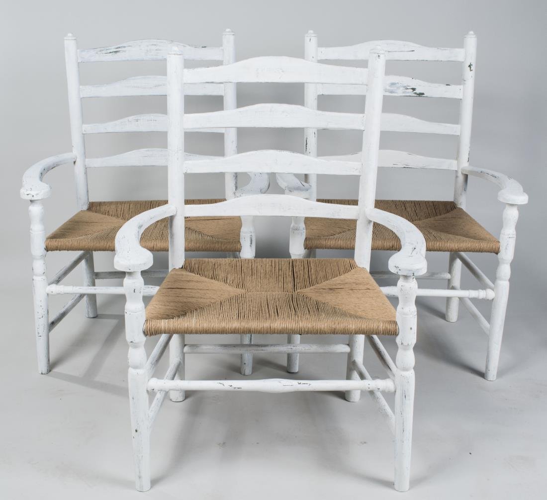Three White Painted Armchairs: Each with ladder back, rush seat, and turned legs joined by a box stretcher. Height 41 inches, width 31 inches, depth 21 inches. Notice to bidders: Condition reports and additional photographs are pro