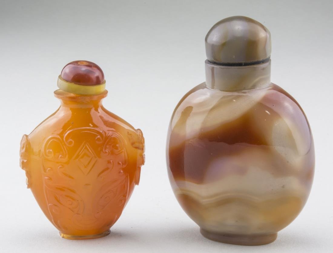Two Chinese Carved Carnelian Snuff Bottles: One, with raised decoration of a dragon's head. Taller, height 2 3/4 inches. Provenance: From the Collection of Erwin A. Raible Notice to bidders: Condition reports and additional photographs are prov