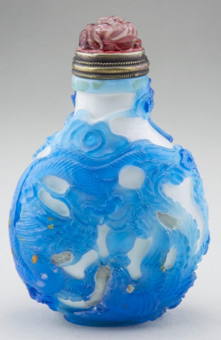 Chinese Cameo Glass Snuff Bottle: Blue dragon decoration on white ground, carved carnelian stopper and metal spoon. Height, 3 5/8 inches. Provenance: From the Collection of Erwin A. Raible Notice to bidders: Condition reports and addi