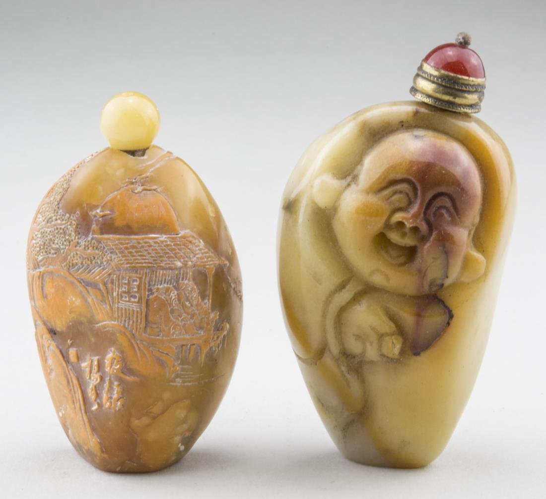 Two Carved Carnelian Snuff Bottles: Both carved naturalistically as pebbles, with raised decoration, one a figure of a laughing man, the other carved with a landscape scene. Taller, height 3 inches. Provenance: From the Collection of Er