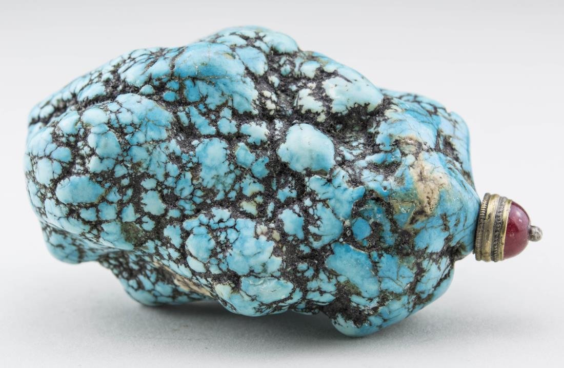 Chinese Turquoise Snuff Bottle: Natural boulder form, carnelian stopper, metal spoon. Height, 3 3/4 inches. Provenance: From the Collection of Erwin A. Raible Notice to bidders: Condition reports and additional photographs are provi