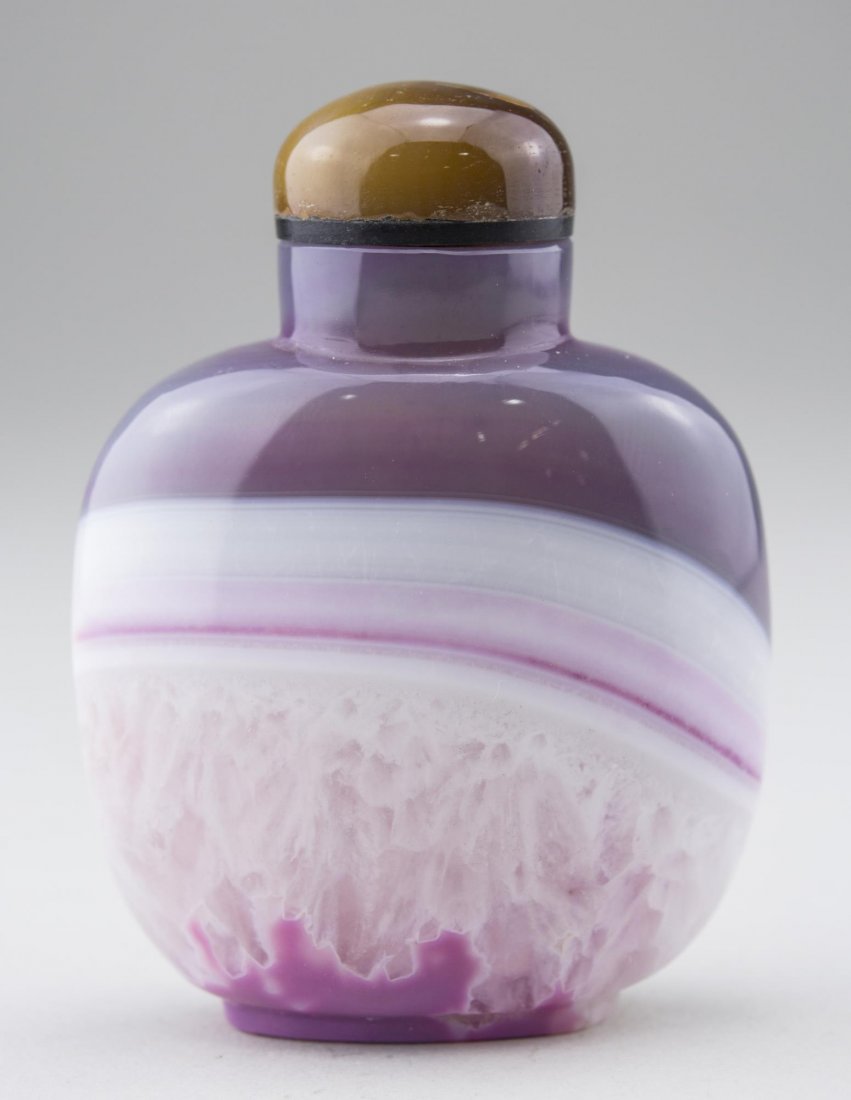 Chinese Carved Hardstone Snuff Bottle: Cylindrical neck, ovoid body, ring foot, lavender and white banded decoration, carved carnelian stopper, bone spoon. Height, 2 7/8 inches. Provenance: From the Collection of Erwin A. Raible Notice to 