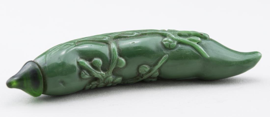Chinese Green Glass Snuff Bottle: In the form of a pepper with carved coral decoration, carved jade stopper, bone spoon. Length, 3 7/8 inches. Provenance: From the Collection of Erwin A. Raible Notice to bidders: Condition reports and