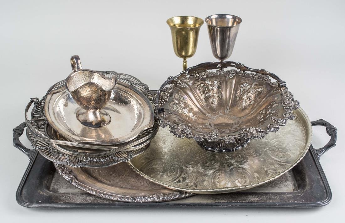 Group of Silver Plated Table Articles: Including a rectangular silver on copper tray with scroll decoration, length over handles 27 1/2 inches; together with two circular trays, sauce boat, two goblets, etc. Notice to bidders: Condition re