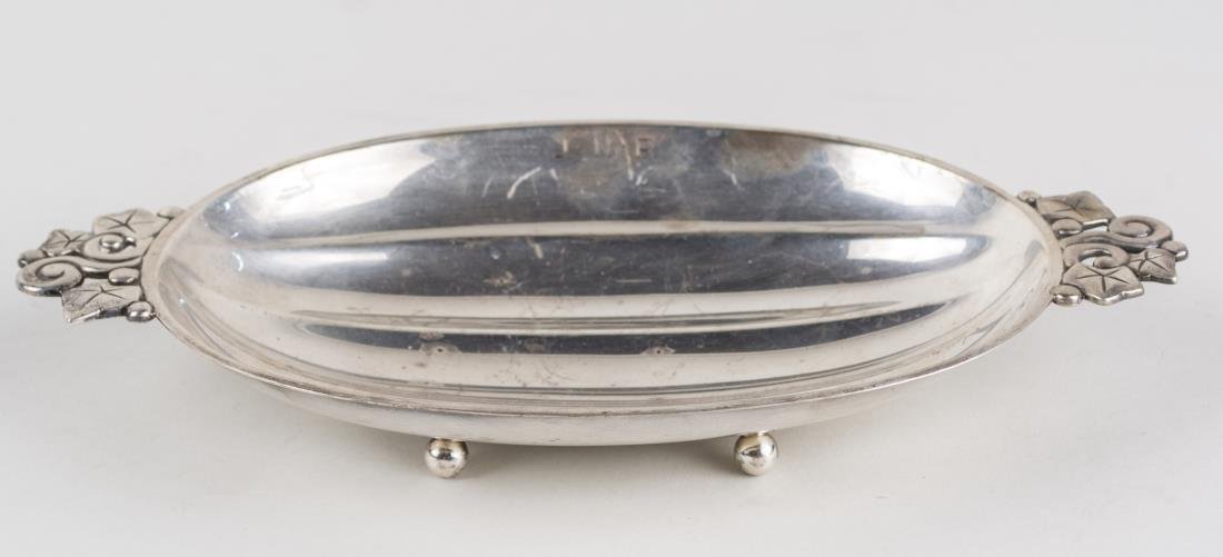Tiffany Makers Sterling Silver Dish: Oval dish with ivy leaf handles, ball feet, monogrammed J.N.R.. Length 10 inches, 260 grams. Notice to bidders: Condition reports and additional photographs are provided by request as a courtesy to ou
