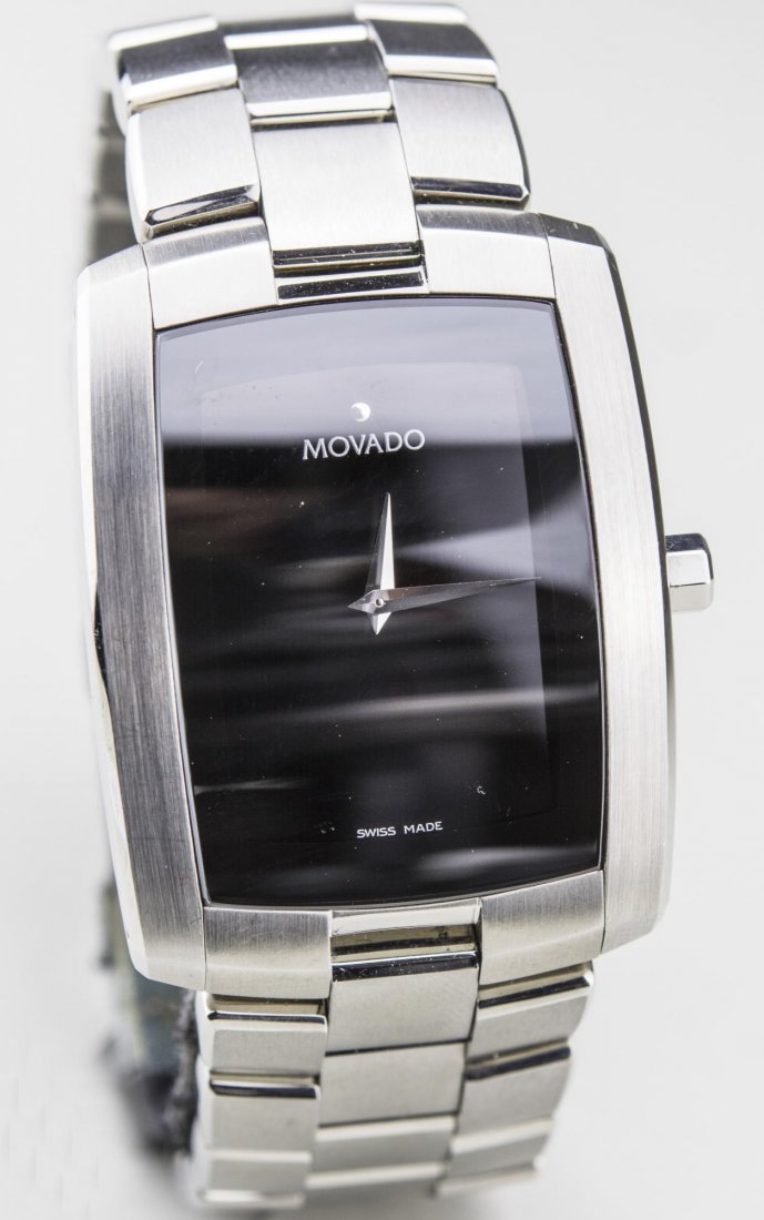 Movado Wristwatch: Black dial without numbers, #2590286, stainless steel band, original box. Notice to bidders: Condition reports and additional photographs are provided by request as a courtesy to our clients, as such