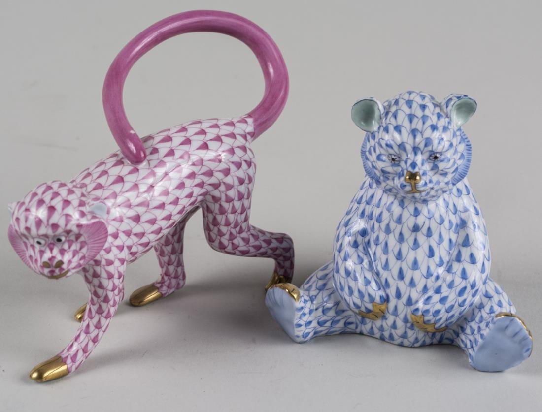 Two Herend Porcelain Figures: Comprising a blue fishnet teddy bear and pink fishnet monkey. Monkey Height 3 5/8 inches. Notice to bidders: Condition reports and additional photographs are provided by request as a courtesy to our c