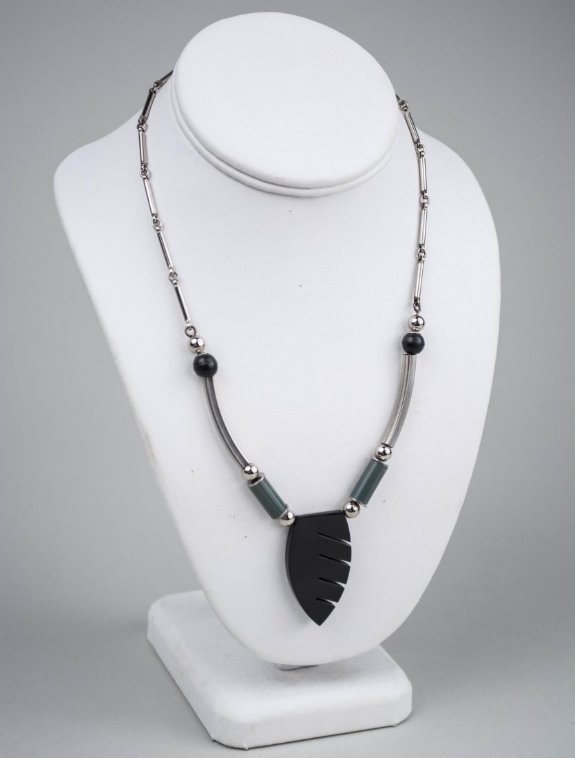 Jakob Bengel Chrome and Galalith Necklace: Chrome tubular beads suspending a black galalith arrow form pendant. Length 18 inches. Notice to bidders: Condition reports and additional photographs are provided by request as a courtesy to our clie