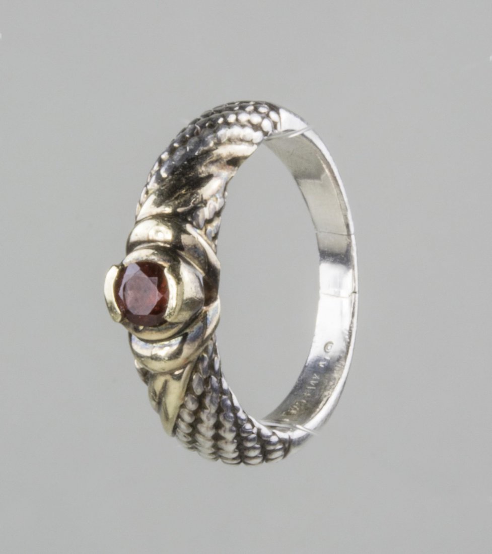 Silver and Gold Ring: Sterling silver twisted rope cast design accented with 14k yellow gold, centering a round faceted ruby. 5.6 grams, size 8 1/4. Notice to bidders: Condition reports and additional photographs are provi