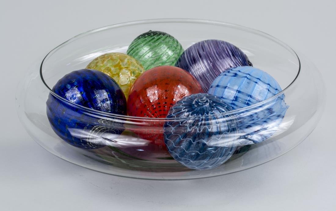Glass Center Bowl and Glass Balls: Colorless glass center bowl with eight blown glass of various colours. Center bowl, diameter 14 inches. Notice to bidders: Condition reports and additional photographs are provided by request as a cou