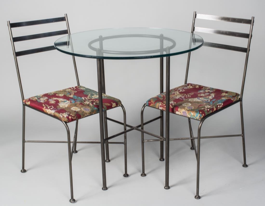 Glass Top Table and Two Chairs: Table with circular glass top on a tubular metal frame with four legs joined by an X stretcher, the chairs with ladder backs and upholstered seats on tubular metal legs joined by X stretchers. Table h