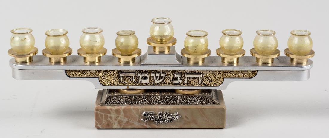 Frank Meisler Menorah: Silver, brass and brushed metal with amber glass lamps on a Jerusalem marble base. Height 3 1/2 inches. Notice to bidders: Condition reports and additional photographs are provided by request as a cou