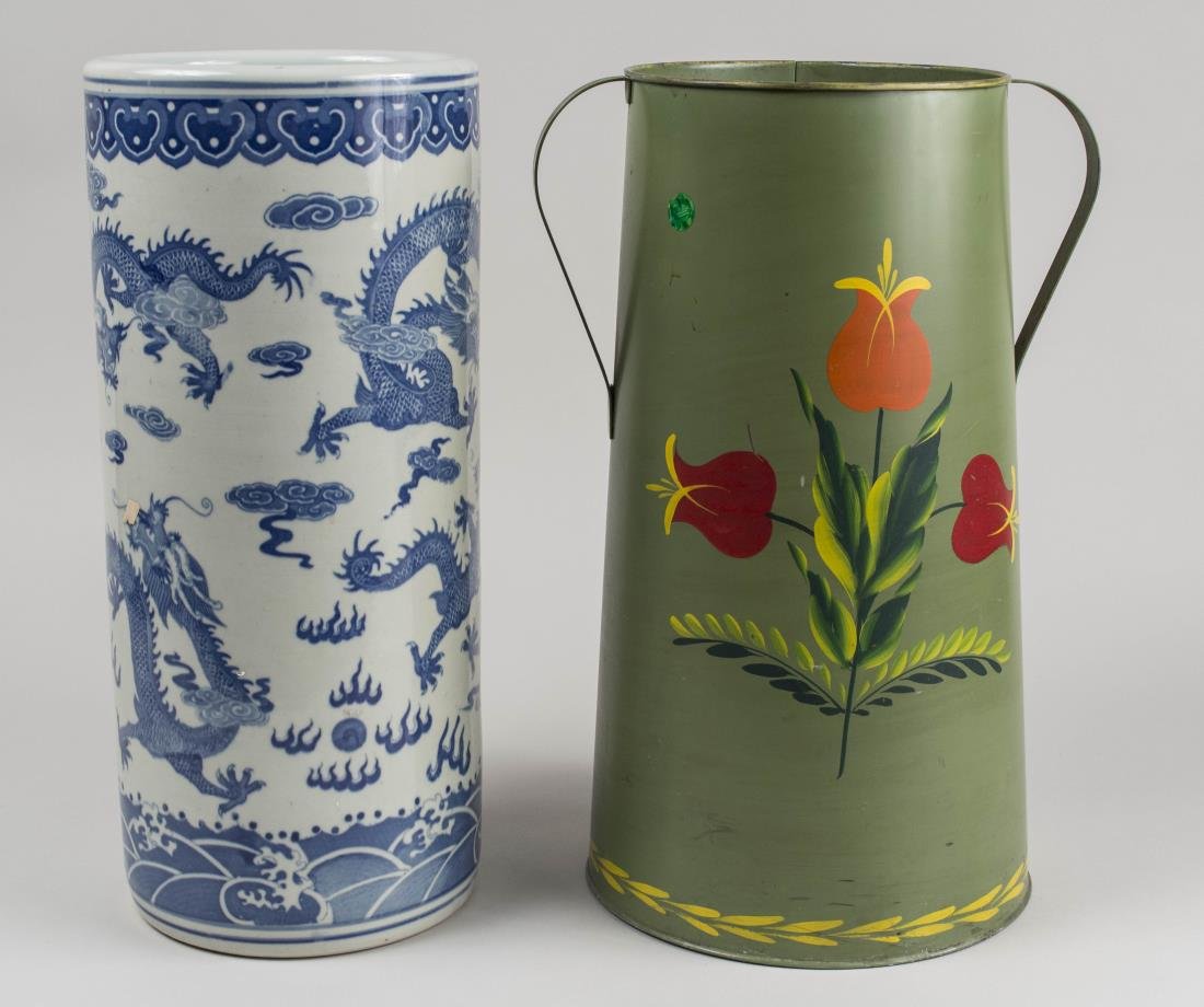 Two Umbrella Stands: One Chinese, blue and white porcelain stand with dragon decoration; the other, a green tole stand with red flower decoration. Chinese umbrella stand, height 18 1/2 inches. Notice to bidders: Condition