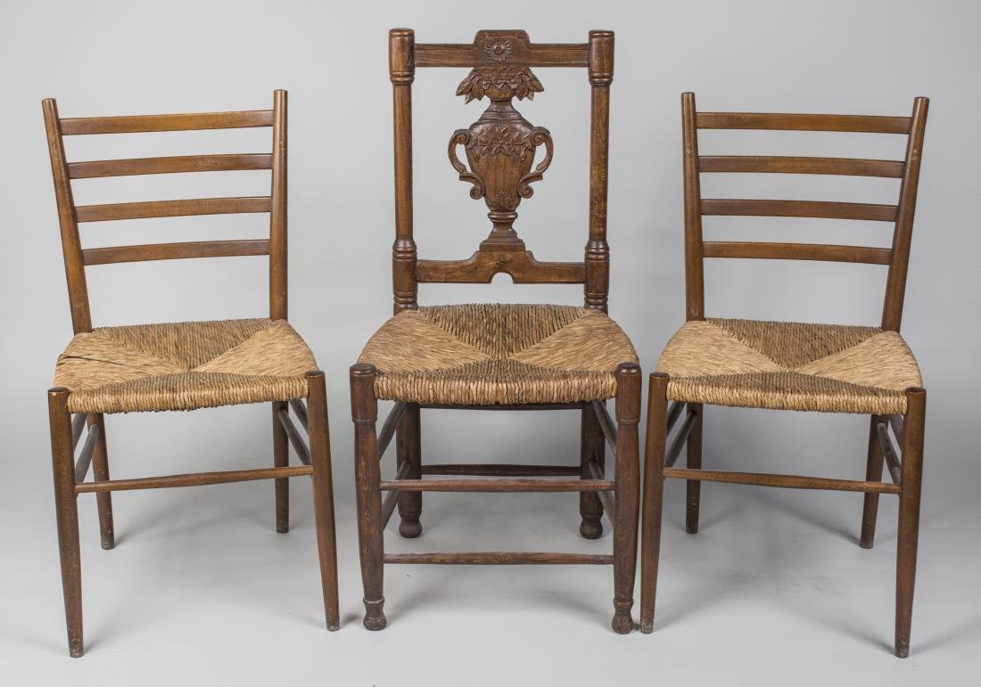 Three Rush Seat Side Chairs: Comprising a pair of ladder back side chairs, and a single side chair with a carved urn form splat. Tallest height 38 inches, width 18 inches, depth 16 inches. Notice to bidders: Condition reports and