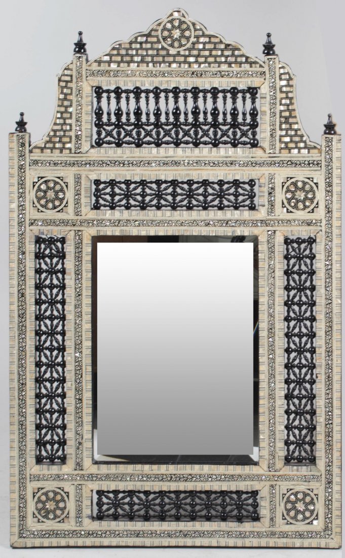 Moroccan Inlaid Mirror: Architectural design with pediment top, mother of pearl inlay, and bobbin turned openwork decoration. 35 1/2 x 22 inches. Notice to bidders: Condition reports and additional photographs are provided b