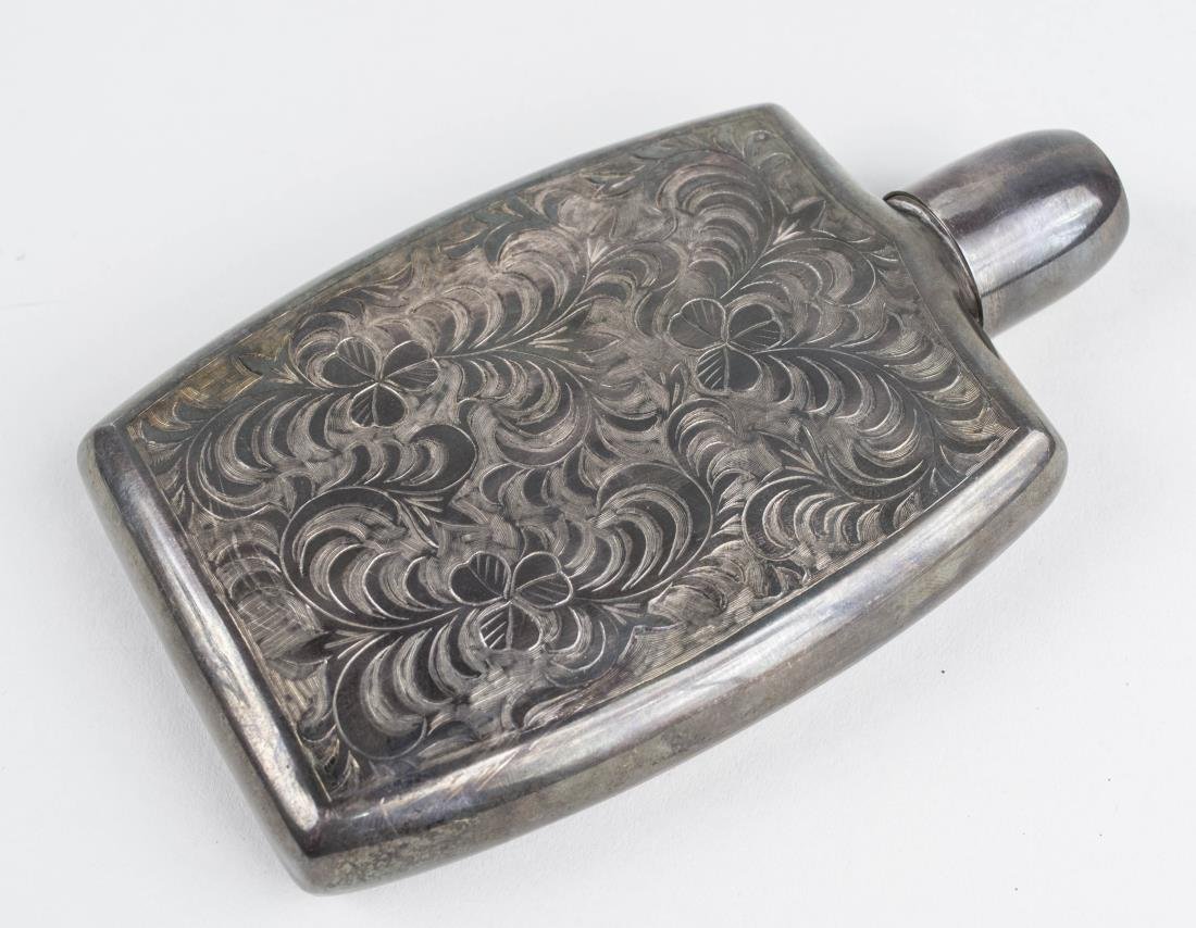 Sterling Silver Flask: Decorated with three shamrocks. Height 5 7/8 inches,150 grams. Notice to bidders: Condition reports and additional photographs are provided by request as a courtesy to our clients, as such any conditi