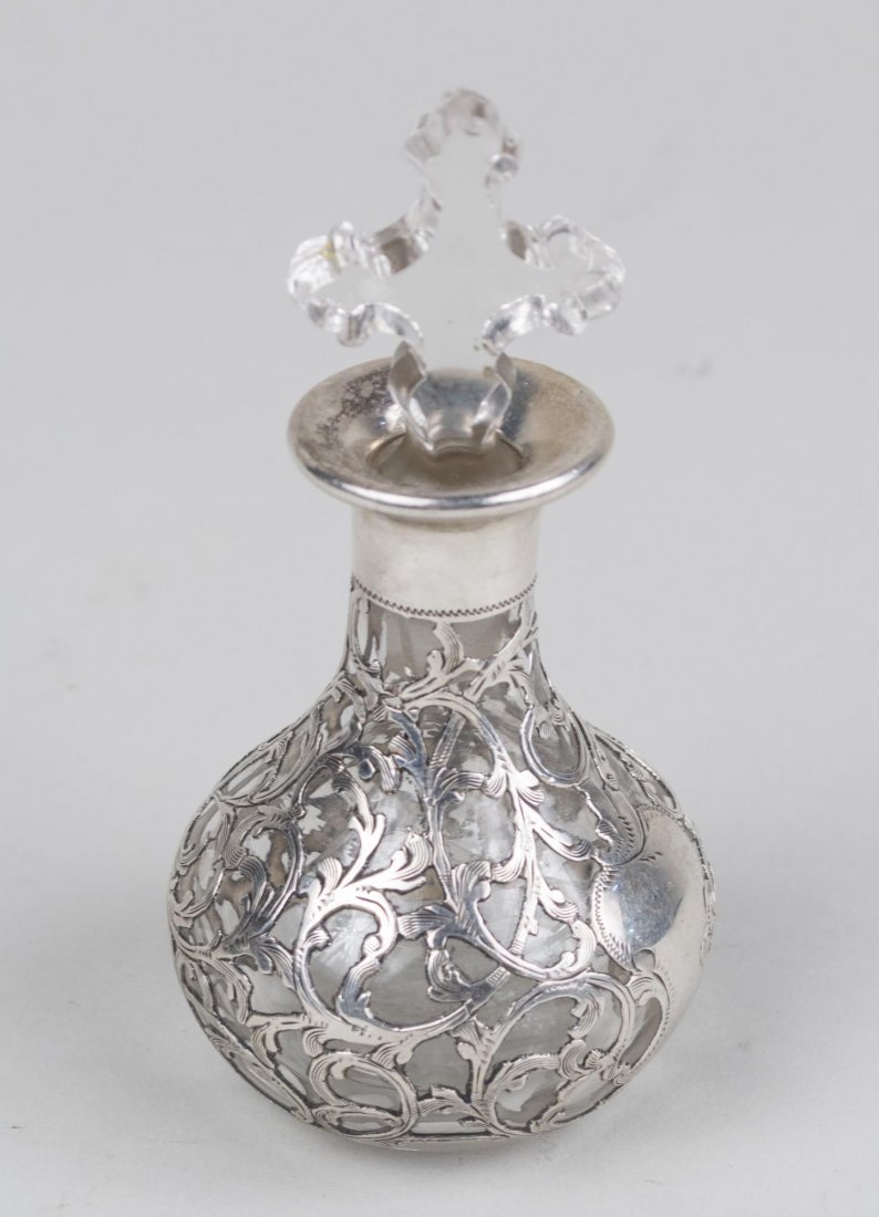 Black Starr & Frost Silver Mounted Bottle: Scroll decoration, signed and marked at the bottom, replaced stopper. Height 4 3/4 inches. Notice to bidders: Condition reports and additional photographs are provided by request as a courtesy to our 