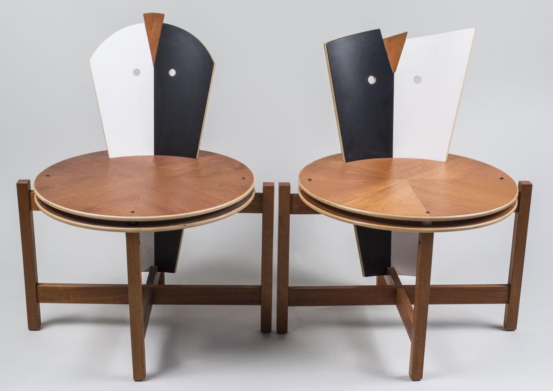 Pair of Modernist Chairs: Probably by James Evanson, circa 1987, stained and painted wood, the backs in the form of a stylized mask, circular seats and rectangular black legs joined by an X stretcher, marked in red under seat,