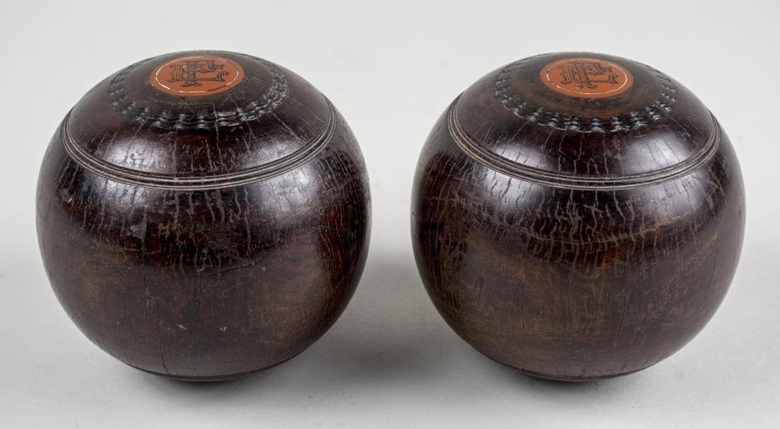 Pair of Wood Game Balls: Diameter, 4 1/2 inches. Notice to bidders: Condition reports and additional photographs are provided by request as a courtesy to our clients, as such any condition report is only an opinion and should