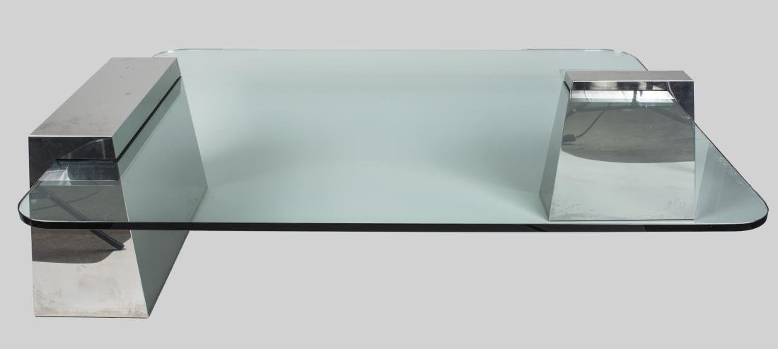 Contemporary Glass Top Chrome Coffee Table: Rectangular glass top with rounded corners, on two offset tapered rectangular chrome supports. Height 18 inches, width 65 inches, depth 46 inches. Notice to bidders: Condition reports and additional p