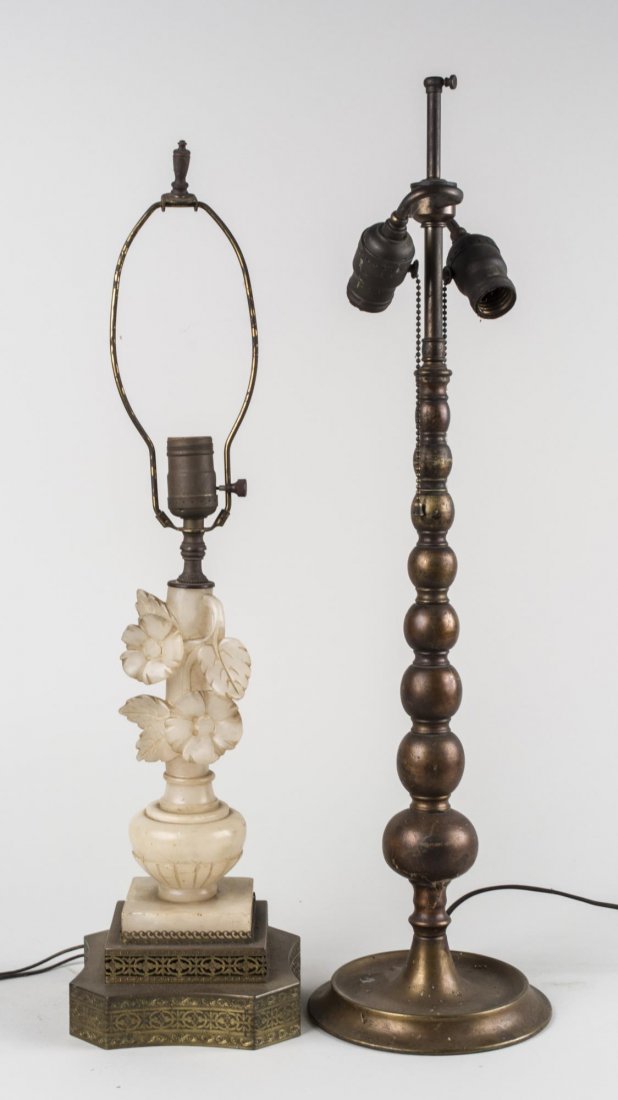 Two Table Lamps: One, a single light marble lamp carved as a vase of flowers, the other, a metal two light lamp designed as a stack of graduated balls. taller height 26 inches. Notice to bidders: Condition reports and