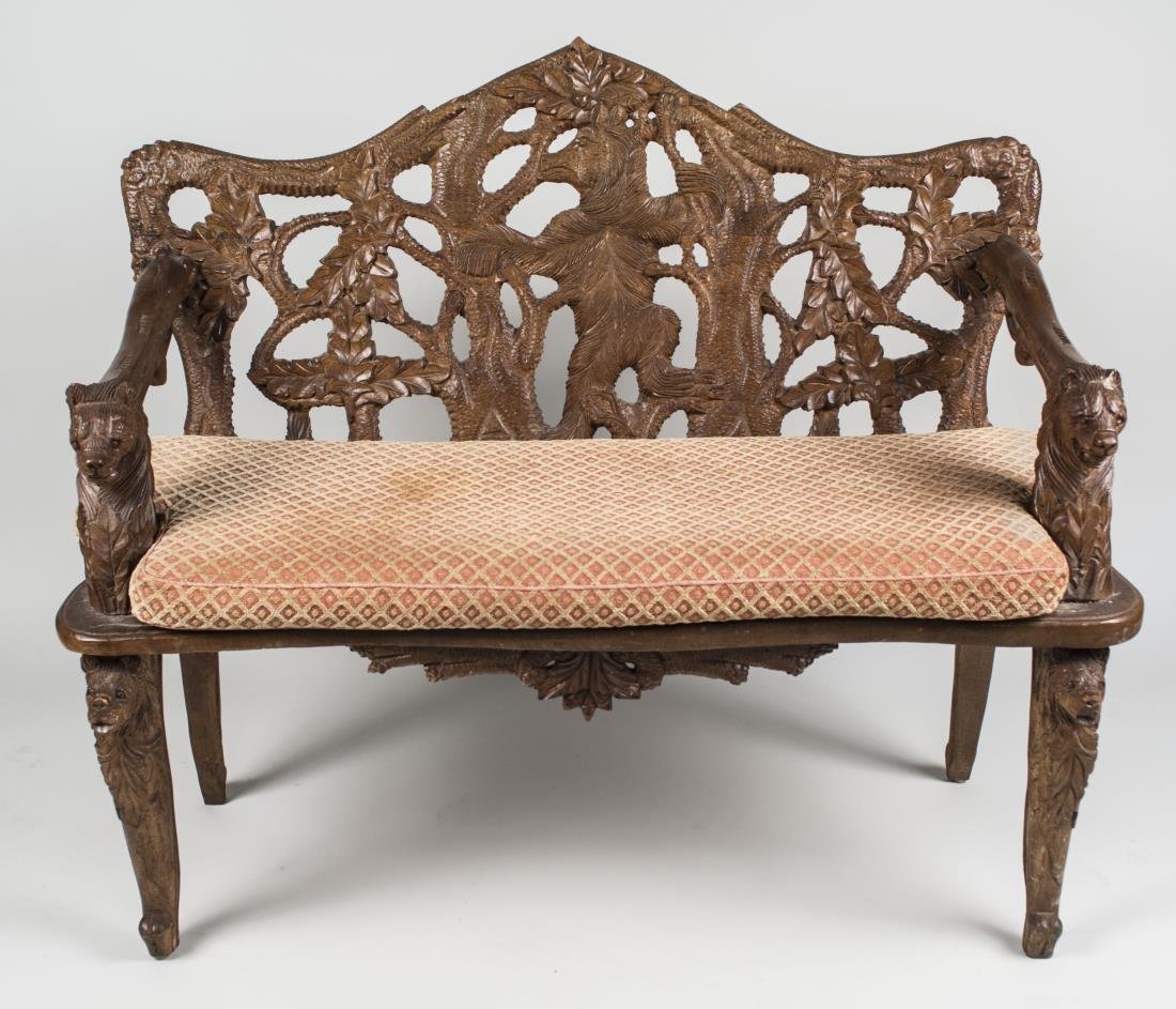 Bavarian Style Carved Bench: Open back carved in the center with a bear, cushion seat, leaf carved leg. Height 40 inches, width 48 inches, depth 21 inches. Notice to bidders: Condition reports and additional photographs are provi