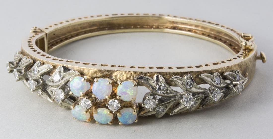 Gold, Opal and Diamond Bangle *: 14k yellow gold, the center set with six opal cabochons flanked by rows of round diamonds. Inside 2 x 1 3/4 inches, 23.2 grams, all inclusive. Notice to bidders: Condition reports and additional photo