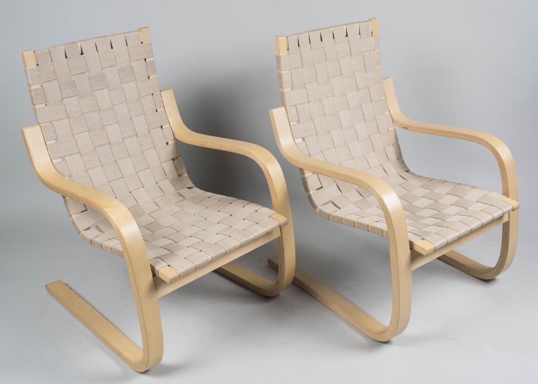 Pair of Alvar Aalto Artek 406 Armchairs: Each with beige canvas woven back and seat on a bent wood frame. Height 34 inches, width 24 inches, depth 28 inches. Notice to bidders: Condition reports and additional photographs are provided by req