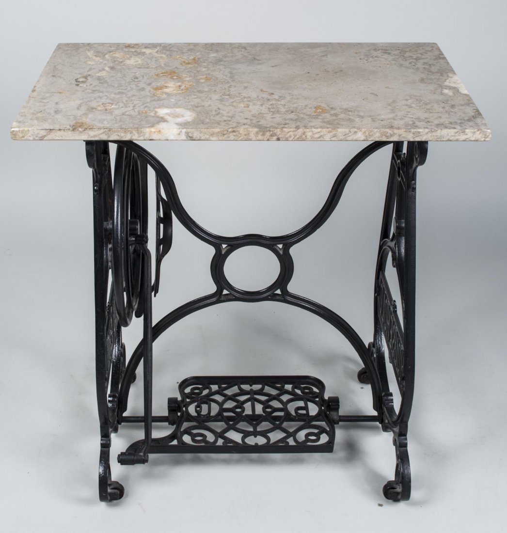 Marble Top Iron Table: Rectangular top on a cast iron sewing machine base. Height 30 inches, width 30 inches, depth 18 inches. Provenance: The Estate of Melvin Bernhardt Notice to bidders: Condition reports and additional p